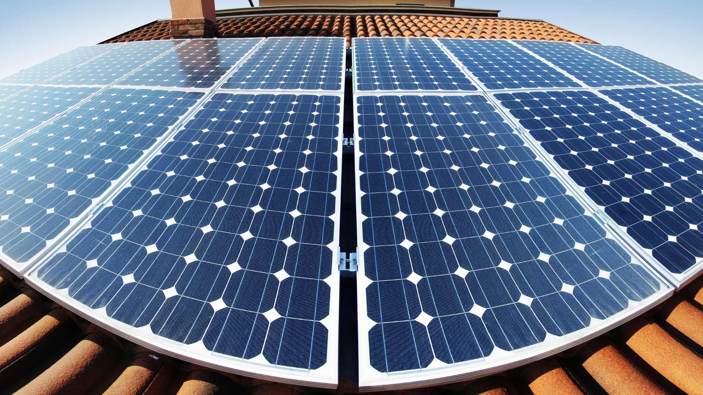 Zonnepanelen op een dak|Vlaamse vlag op een veld met zonnepanelen